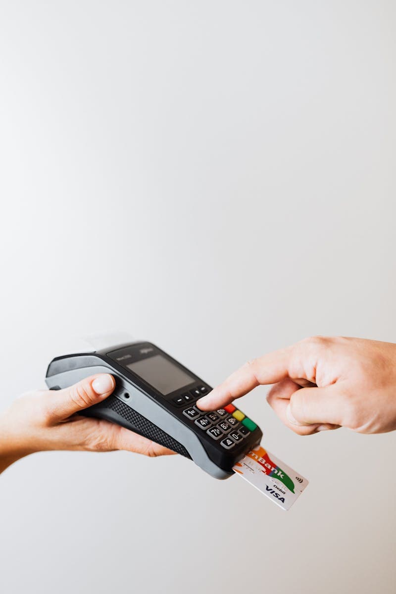 Person using handheld payment terminal keypad — representative of portable POS category